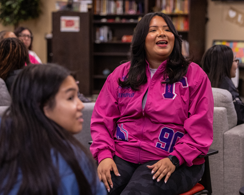 Students sitting and laughing at event.